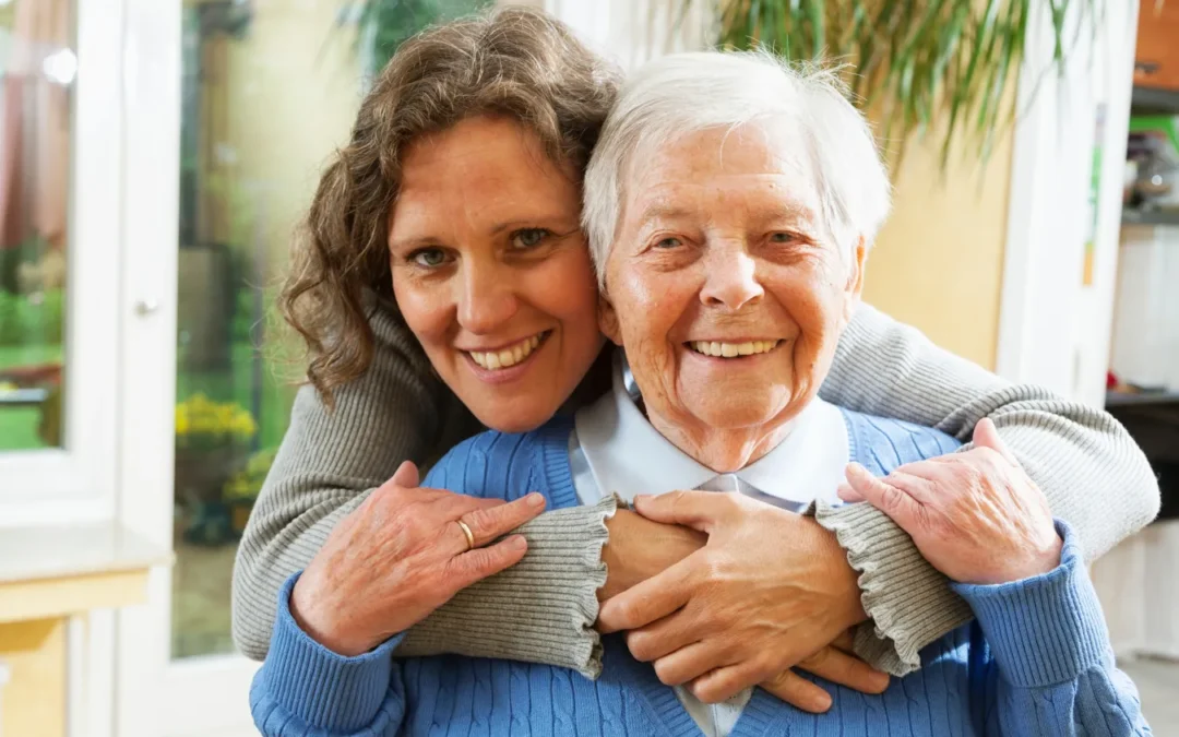 Younger woman with arms around elderly woman