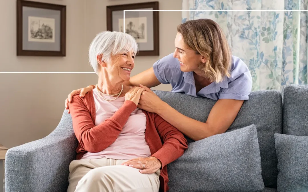 Older woman holding hands on couch with younger woman